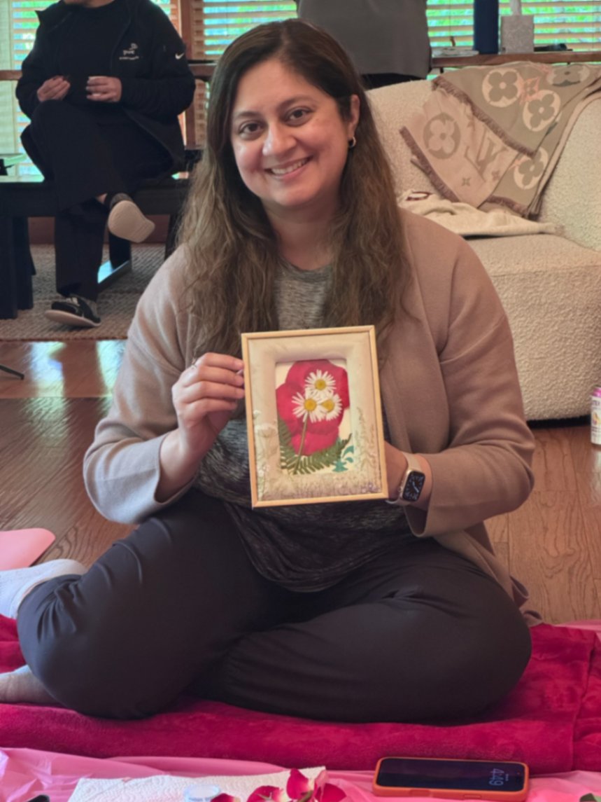 Dr. Fatima holding pressed-flower art